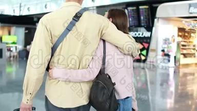 年轻夫妇的腿与行李在机场，旅行和商务旅行的概念。 夫妻在机场赶时间